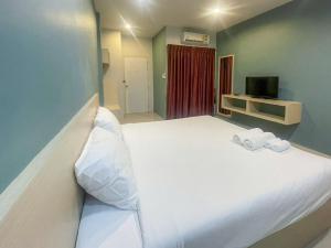 um quarto com uma grande cama branca e 2 toalhas em Hop On Phuket em Ban Bo Han