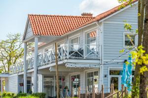 ein weißes Haus mit einem Balkon mit Stühlen in der Unterkunft EuroParcs Veluwemeer in Nunspeet