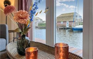 a table with a vase of flowers and a window at Lovely Home In Breukelen With House Sea View in Breukelen