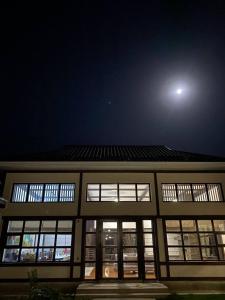 Un edificio di notte con la luna nel cielo di Happy Flower Guesthouse a Verkhnyaya Alaarcha