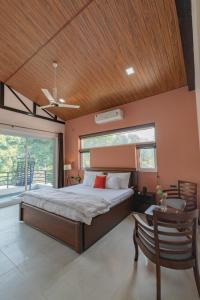 ein Schlafzimmer mit einem Bett und einer Holzdecke in der Unterkunft SaffronStays Wildernest, Dehradun - pet-friendly Swedish home amidst nature in Dehradun