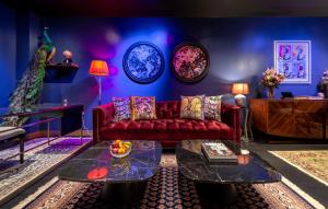 sala de estar con sofá rojo y pared azul en Hux Hotel, Kensington en Londres