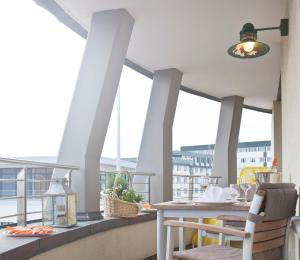 einen Balkon mit einem Tisch, Stühlen und Fenstern in der Unterkunft Michels Villa Nordsee in Norderney