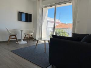 sala de estar con sofá, mesa y ventana en Résidence des Tilleuls proximité plage et commerces en Royan