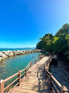 un ponte di legno sopra un corpo d'acqua con delle persone sopra. di Apartamento em frente ao clube do Porto Real Resort ad Angra dos Reis