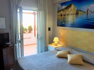 1 dormitorio con cama y ventana grande en Hotel Ortensia, en Ponza