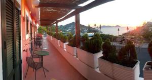 balcón con mesa, sillas y macetas en Hotel Ortensia, en Ponza