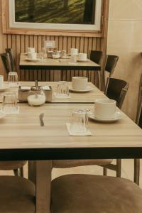 a table with chairs and plates and glasses on it at Alas Hotel in San Rafael