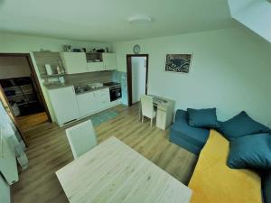 a living room with a blue couch and a kitchen at Apartma Butterfly in Škofja Loka