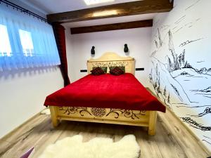 een slaapkamer met een rood bed in een kamer bij Domek Góralski na Ubocy z jacuzzi in Białka Tatrzanska