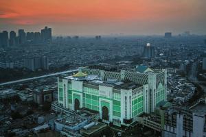 un grand bâtiment dans une ville au coucher du soleil dans l'établissement Yellow Bee Tanah Abang, à Jakarta