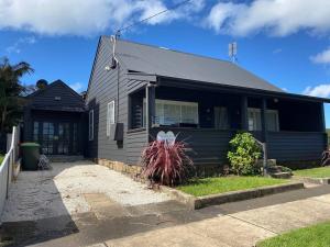 uma casa negra com uma casa em Driftwood Beach House em Kiama