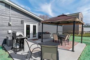 un patio con mesa y sombrilla en Gazebo 4BR Ping Pong Arcade Room en Rapid City