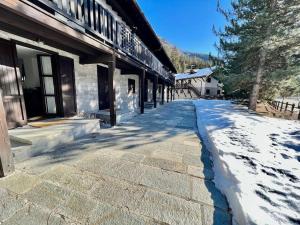 um passeio coberto de neve em frente a um edifício em Chalet le Pigne Gressoney Saint Jean em Gressoney-Saint-Jean