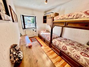 um quarto com 2 beliches e uma mesa de madeira em Chalet le Pigne Gressoney Saint Jean em Gressoney-Saint-Jean