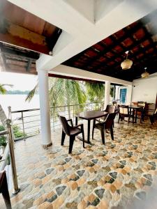 - un patio avec une table et des chaises sur un sol en pierre dans l'établissement Lagoon Breeze Resort, à Batticaloa