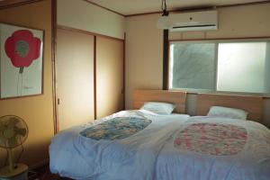 1 dormitorio con 1 cama grande y ventana en Private house KUMANOYASAI BASE en Tanabe