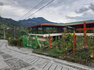 un edificio al lado de una carretera con montañas en De Pájaros y Flores Alojamiento Rural Támesis en Támesis