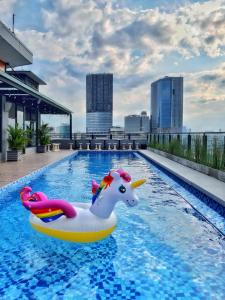 einen Pool mit einem Einhorn-Schwimmer auf einem Gebäude in der Unterkunft Surabaya River View Hotel in Surabaya