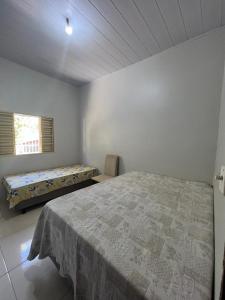 Habitación blanca con cama y ventana en CASA DE FÉRIAS en Barra do Garças