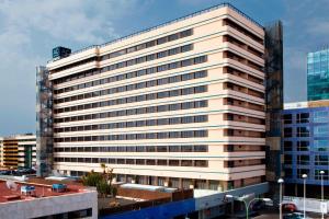 un alto edificio de oficinas blanco con muchas ventanas en AC Hotel Iberia Las Palmas by Marriott en Las Palmas de Gran Canaria