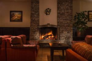 sala de estar con sofás y chimenea en Mura Hotel en Bansko