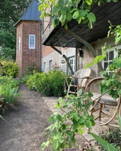 un banc installé à l'extérieur d'une maison avec un bâtiment dans l'établissement Gartnerhuset på Kollerup, à Hadsten Stationsby