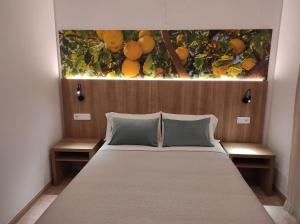 een slaapkamer met een bed met een schilderij erboven bij Hostal Nadal in Sóller