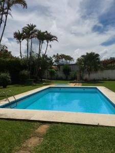 una piscina en un patio con palmeras en Casa Aconchegante - Circuito Teresópolis Friburgo en Teresópolis