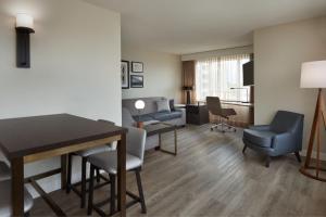 uma sala de estar com mesa e cadeiras num quarto de hotel em Residence Inn by Marriott London Canada em London