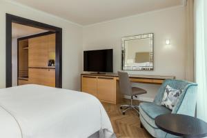 - une chambre avec un lit, un bureau et une télévision dans l'établissement The Westin Grand Berlin, à Berlin