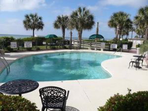 una piscina con sedie, tavoli e palme di Ocean Front, Private Balconies a Myrtle Beach