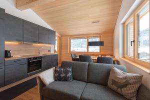 a living room with a couch and a kitchen at BergZeit Schoppernau in Schoppernau