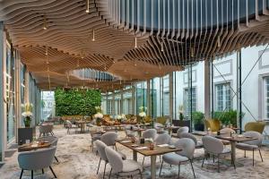 a restaurant with wooden ceilings and tables and chairs at Hotel Verte, Warsaw, Autograph Collection in Warsaw