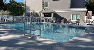 uma piscina com uma escada no meio em SureStay Plus Hotel by Best Western Vero Beach em Vero Beach