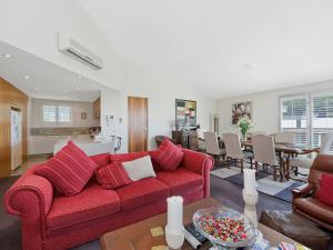 sala de estar con sofá rojo y comedor en Louvres en Wye River