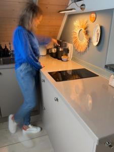 een vrouw die in een keuken staat om eten te bereiden bij Guesthouse in het Voorhuys in Doesburg