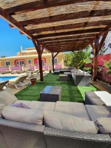 eine Terrasse mit einem Sofa unter einer hölzernen Pergola in der Unterkunft Vila Graciosa - Tranquility Oasis in Lagos