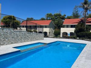 a swimming pool in front of a house at Blueys Beach Villa Manyana 11 in Blueys Beach