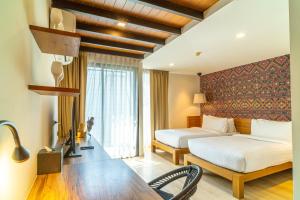 um quarto de hotel com duas camas e uma mesa em Amber Boutique Silom em Bangkok