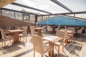 ein Restaurant mit Tischen und Stühlen auf einer Terrasse in der Unterkunft Deryaman Hotel Trabzon in Trabzon