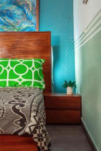 1 dormitorio con 1 cama con almohada verde en PALM Springs Bed & Breakfast en Limbe