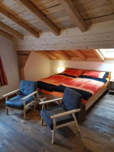 1 dormitorio con 1 cama y 2 sillas en Chalet-Daheim-Fiesch 3,5-Zimmerwohnung, en Fiesch