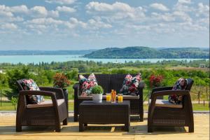 um pátio com cadeiras de vime e uma mesa com vista em Lotti Residnece Familyar em Balatonfüred