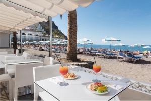 una mesa con comida y bebida en la playa en Mogan Princess & Beach Club en Mogán