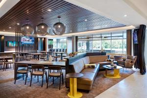 un restaurante con sofá, mesas y sillas en SpringHill Suites by Marriott Austin North, en Austin