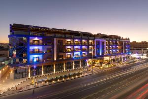 un edificio con luces azules en una calle de la ciudad en Le Reve Hotel en Taif