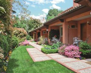 una casa con un jardín con flores y plantas en La Quinta de los Cedros, en Madrid