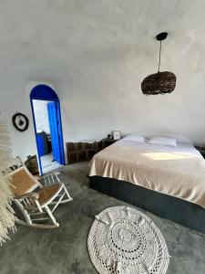 - une chambre avec un lit, une chaise et une porte bleue dans l'établissement Bahareque glamping, à Barichara