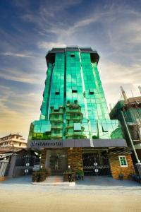 a tall green building with a sign on it at HADJENS HOTEL in Mwanza